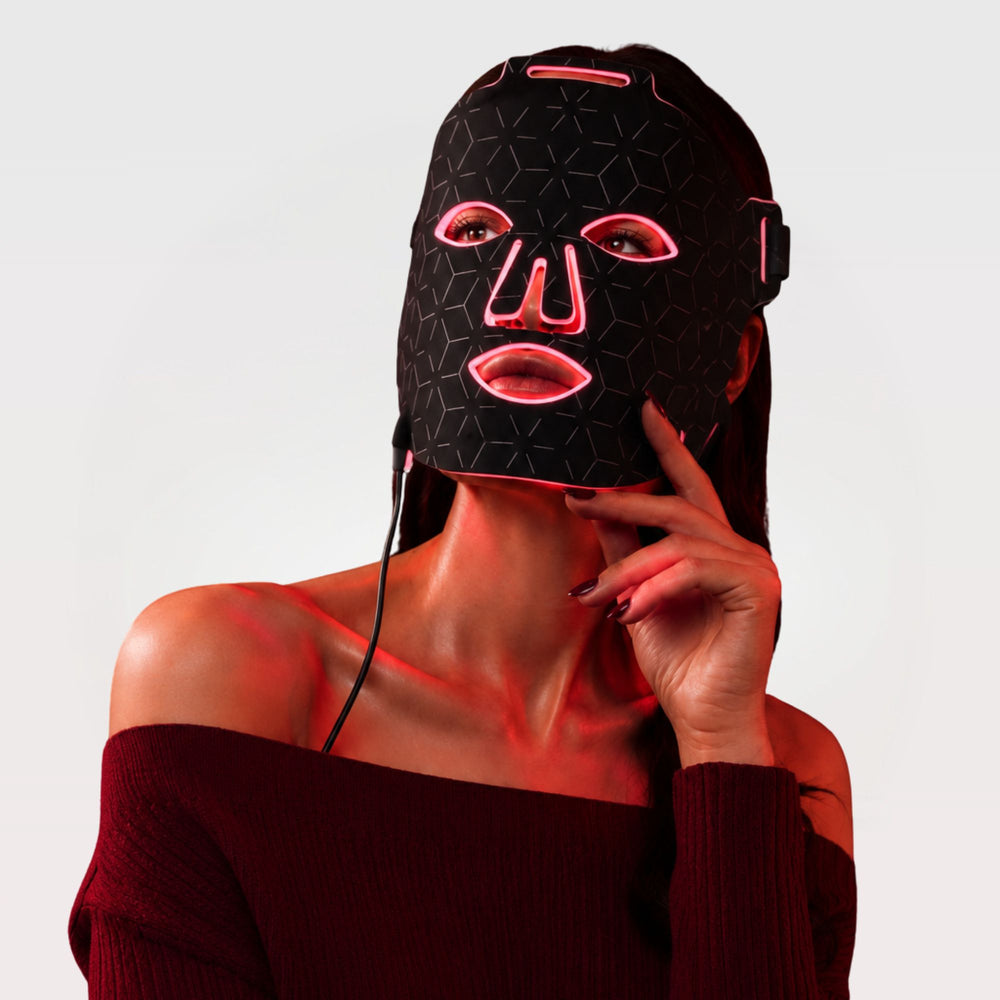 A woman wearing a Luminmax LED light therapy face mask