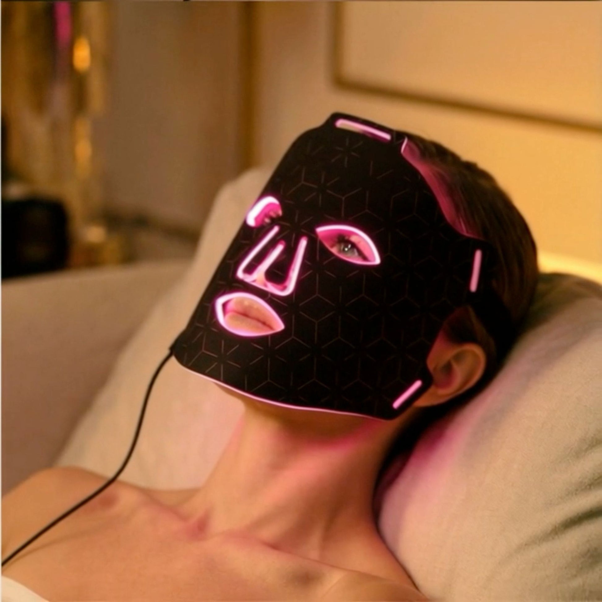 Woman relaxing at home while wearing LED red light therapy face mask