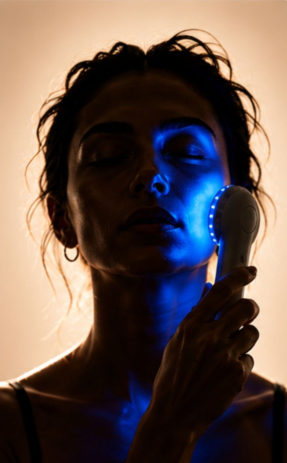 Woman receiving blue LED light therapy to help reduce breakouts and support clearer-looking skin.