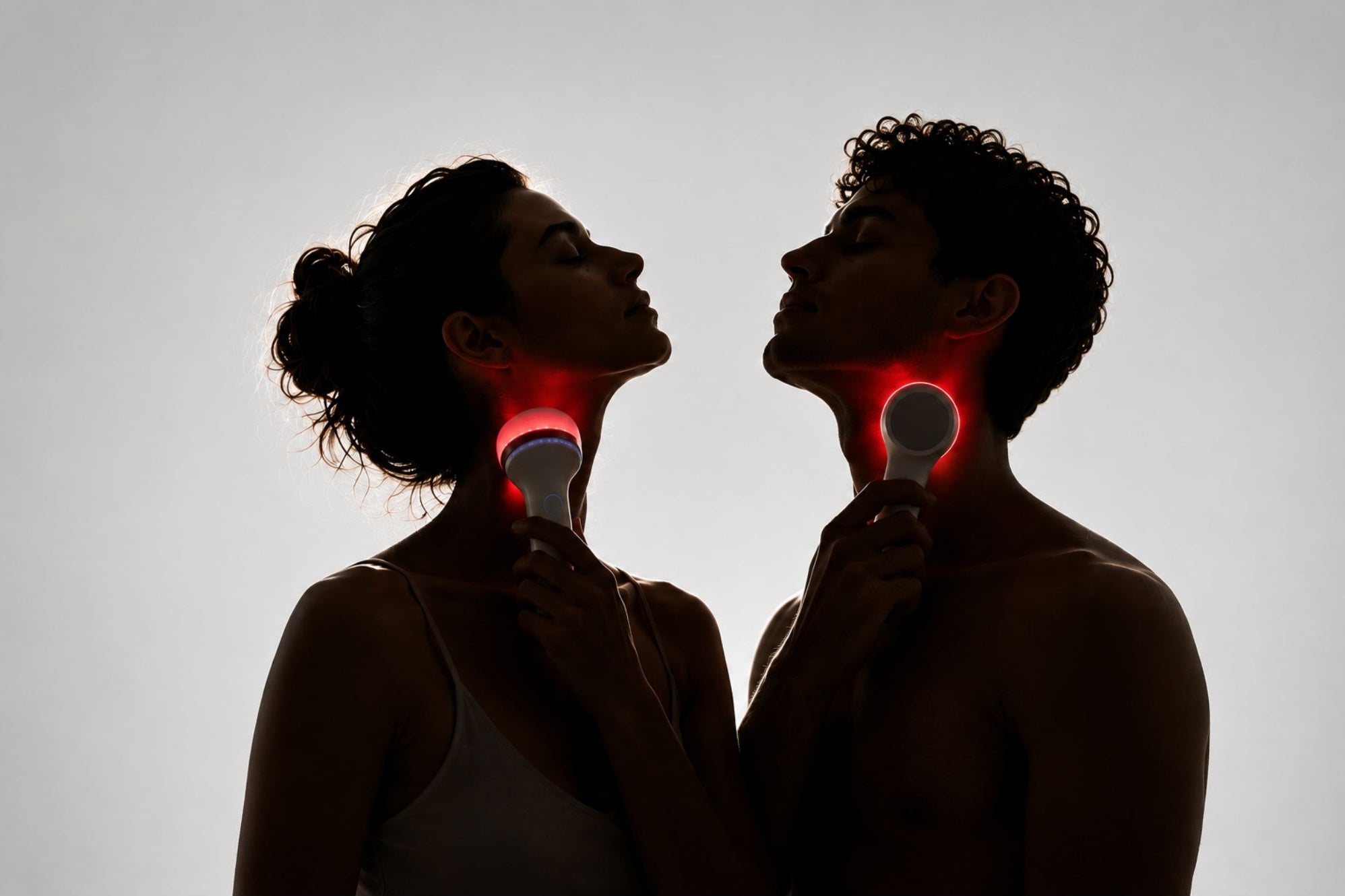 Woman and man using LED light therapy devices on their necks